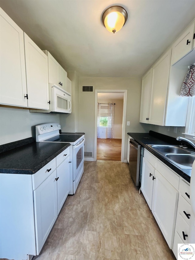 607 Laurel St, Warrensburg, MO 64093 - kitchen featuring white appliances, white cabinetry, dark countertops, and light flooring