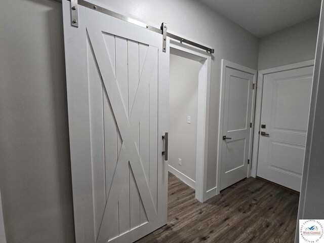 61 NW 247th Rd, Clinton, MO 64735 - hall featuring a barn door, dark wood finished floors, and baseboards