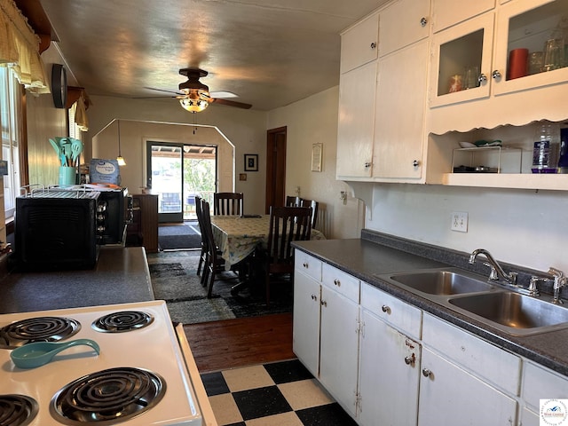 kitchen featuring tile patterned floors, a sink, a ceiling fan, and white cabinets
