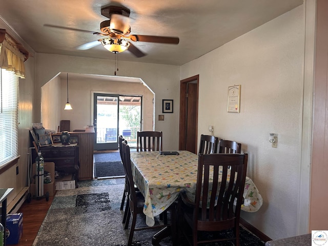 dining space featuring a ceiling fan and dark wood-type flooring