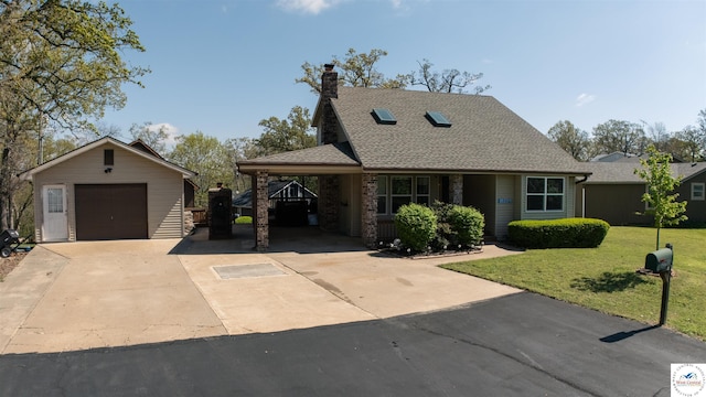 view of front of home featuring a front yard, a shingled roof, an outbuilding, driveway, and a chimney