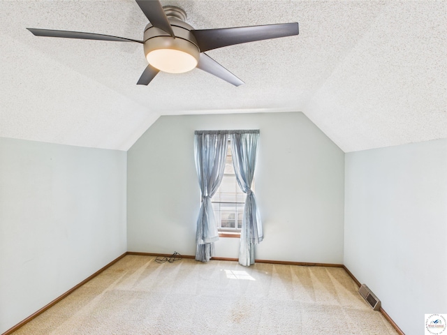 bonus room with a textured ceiling, vaulted ceiling, a ceiling fan, carpet floors, and baseboards