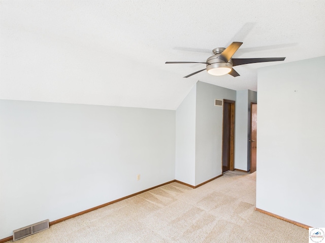additional living space featuring ceiling fan, light carpet, and baseboards