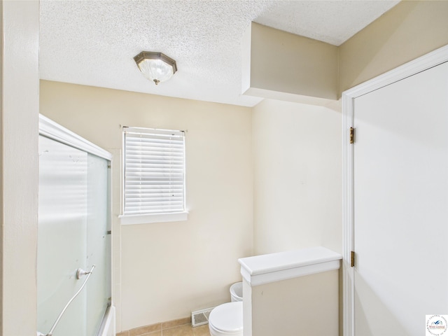 full bathroom with toilet, tile patterned flooring, enclosed tub / shower combo, and baseboards