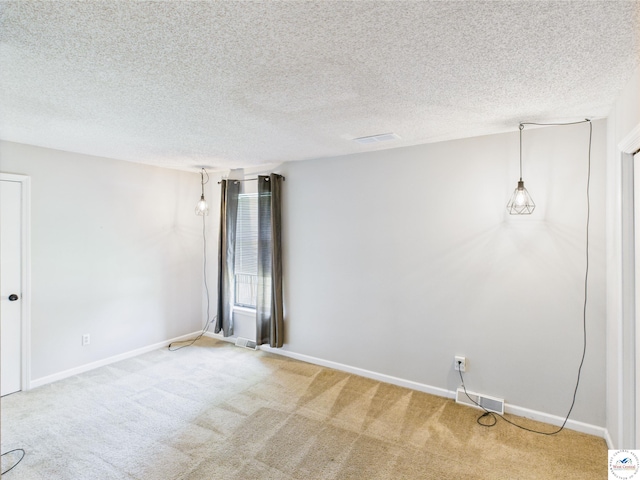 carpeted empty room featuring baseboards and a textured ceiling