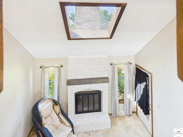 living area featuring a brick fireplace, plenty of natural light, carpet, and baseboards