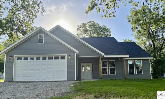 view of front of home featuring driveway, a front yard, an attached garage, and a shingled roof