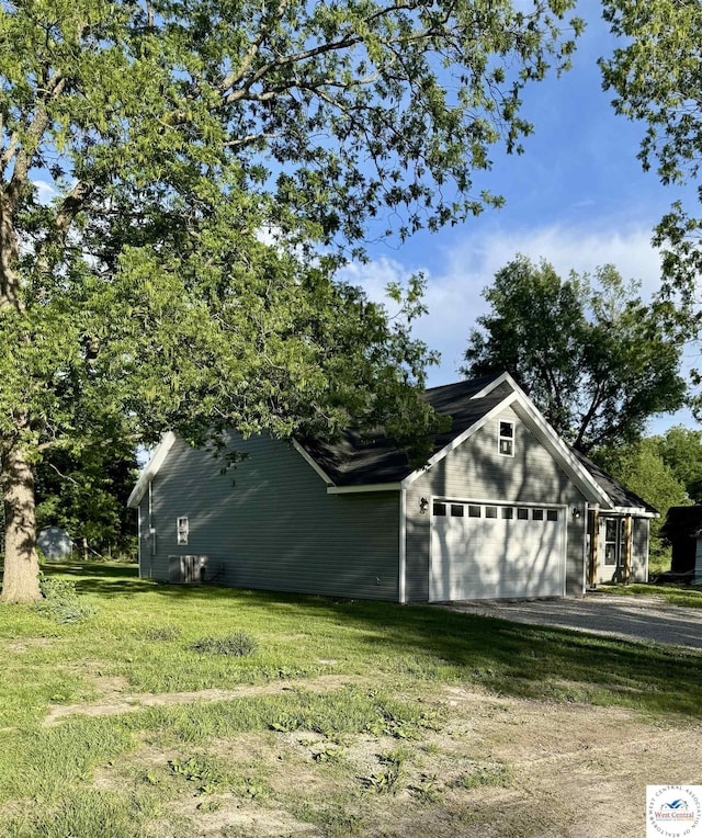 view of home's exterior with driveway, a garage, and a lawn
