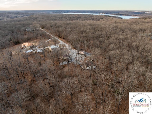 birds eye view of property with a water view and a view of trees