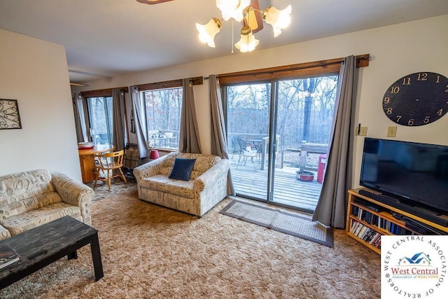 carpeted living room featuring ceiling fan with notable chandelier