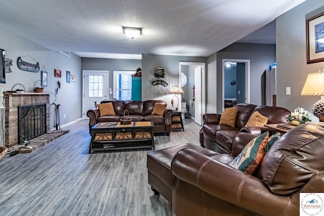 25733 Macks Ave, Warsaw, MO 65355 - living room with a fireplace, a textured ceiling, wood finished floors, and baseboards