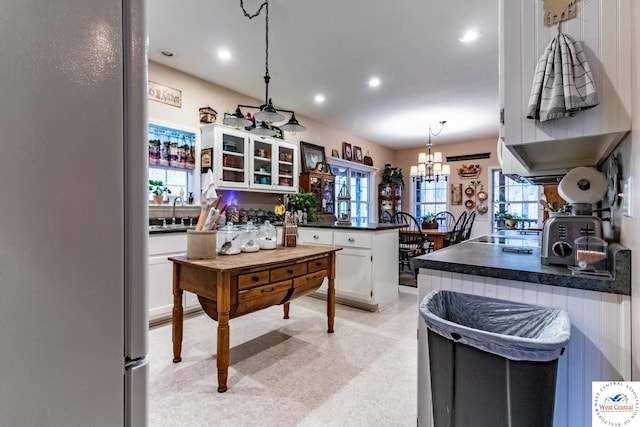25733 Macks Ave, Warsaw, MO 65355 - kitchen with white cabinetry, dark countertops, plenty of natural light, freestanding refrigerator, and a peninsula
