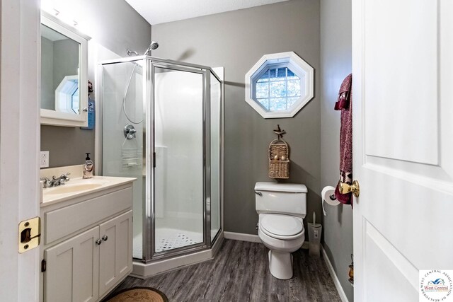 25733 Macks Ave, Warsaw, MO 65355 - bathroom featuring wood finished floors, toilet, vanity, baseboards, and a stall shower