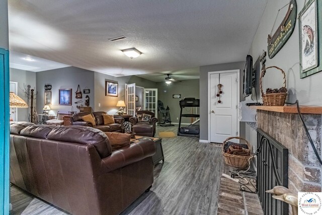 25733 Macks Ave, Warsaw, MO 65355 - living room with visible vents, wood finished floors, a ceiling fan, and a fireplace with raised hearth