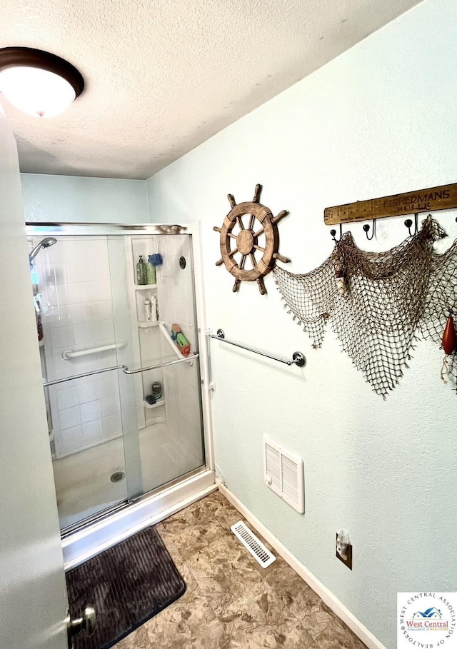 bathroom with visible vents, a shower stall, and a textured ceiling