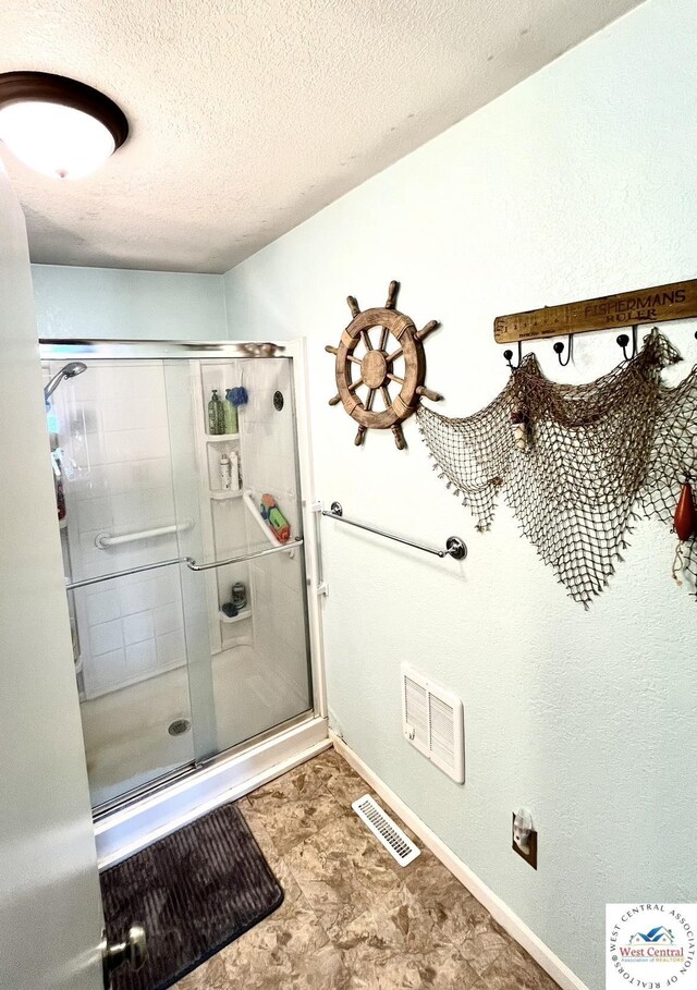19242 Quail Rd, Warsaw, MO 65355 - bathroom with visible vents, a shower stall, and a textured ceiling