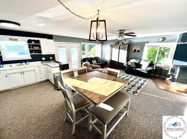19242 Quail Rd, Warsaw, MO 65355 - dining room featuring a ceiling fan, light carpet, a textured ceiling, and french doors
