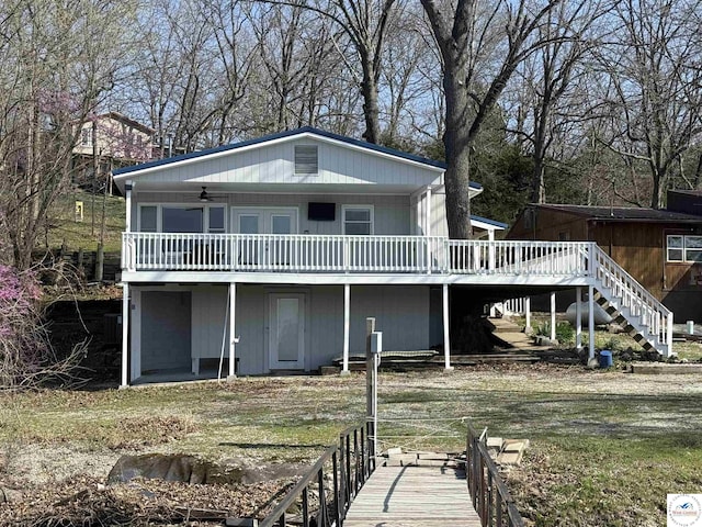 back of house featuring stairway, a deck, and ceiling fan