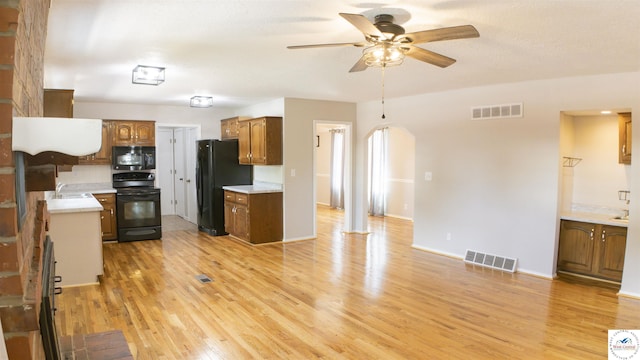 1903 E Alfresco St, Clinton, MO 64735 - kitchen featuring black appliances, ceiling fan, light wood-style flooring, light countertops, and arched walkways