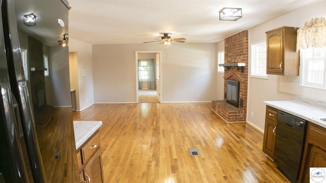 1903 E Alfresco St, Clinton, MO 64735 - kitchen featuring dishwasher, ceiling fan, light countertops, and a brick fireplace