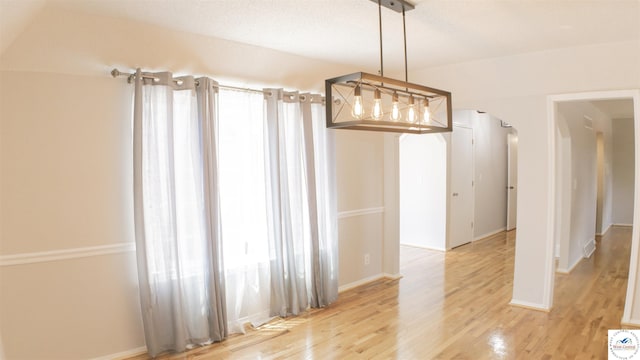 1903 E Alfresco St, Clinton, MO 64735 - empty room with arched walkways and light wood-style floors