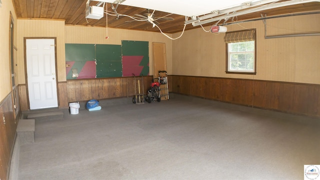 1903 E Alfresco St, Clinton, MO 64735 - garage featuring a garage door opener, wood walls, and wainscoting