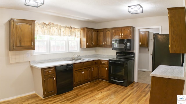 1903 E Alfresco St, Clinton, MO 64735 - kitchen featuring black appliances, tasteful backsplash, light wood-style floors, and light countertops
