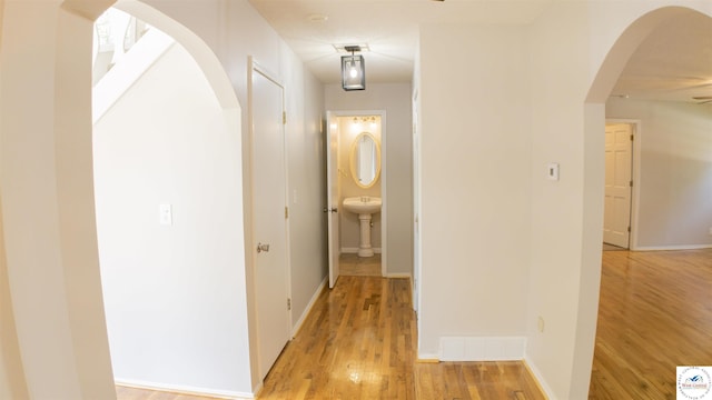 1903 E Alfresco St, Clinton, MO 64735 - hallway with light wood-style floors and arched walkways