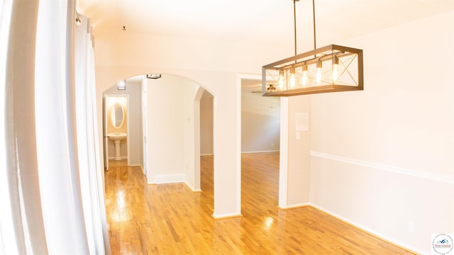 1903 E Alfresco St, Clinton, MO 64735 - corridor featuring arched walkways and light wood-style flooring
