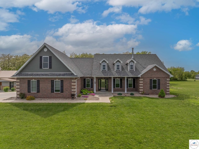 3610 Cambridge Dr, Sedalia, MO 65301 - view of front of house featuring a front yard, a shingled roof, brick siding, and covered porch