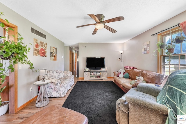 living room with a ceiling fan, wood finished floors, and baseboards