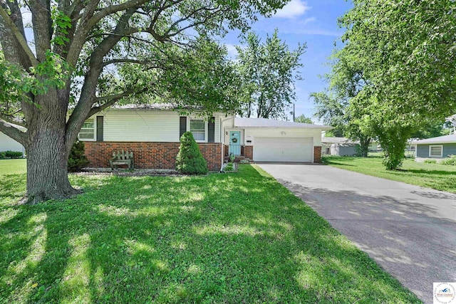 split level home with brick siding, a front yard, driveway, and a garage