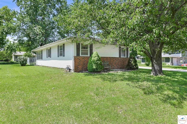 view of home's exterior featuring brick siding and a lawn