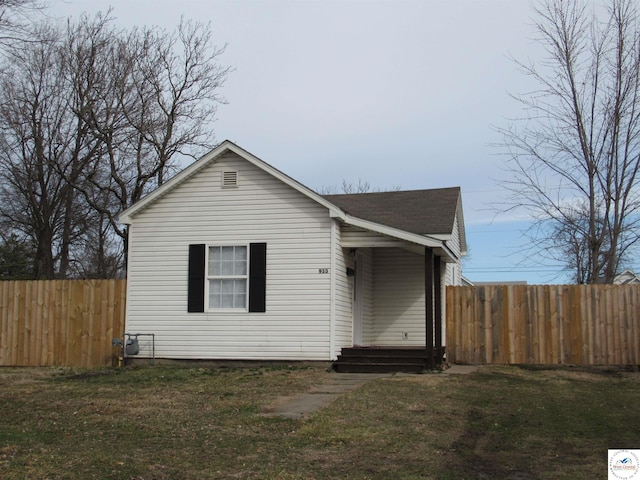 bungalow featuring a front yard, roof with shingles, and fence