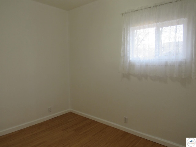 unfurnished room with wood finished floors and baseboards