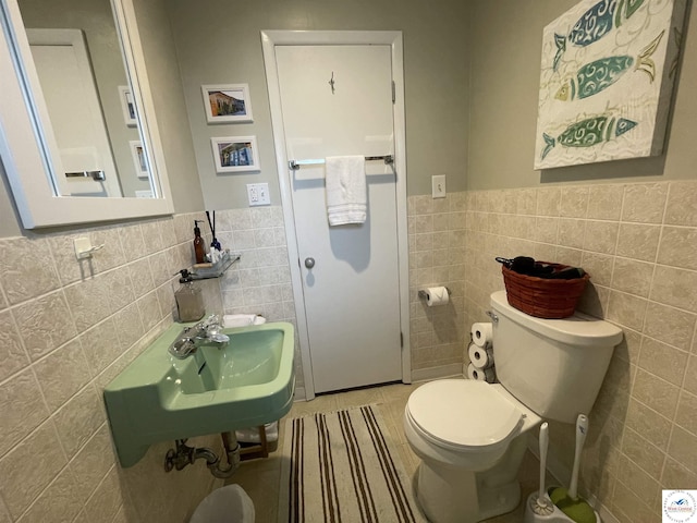 26835 Carefree Ln, Warsaw, MO 65355 - bathroom featuring tile walls, wainscoting, toilet, tile patterned flooring, and a sink
