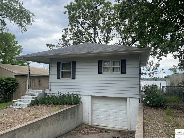 26835 Carefree Ln, Warsaw, MO 65355 - view of front facade featuring a garage and a shingled roof