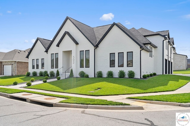 view of front of house featuring brick siding and a front yard
