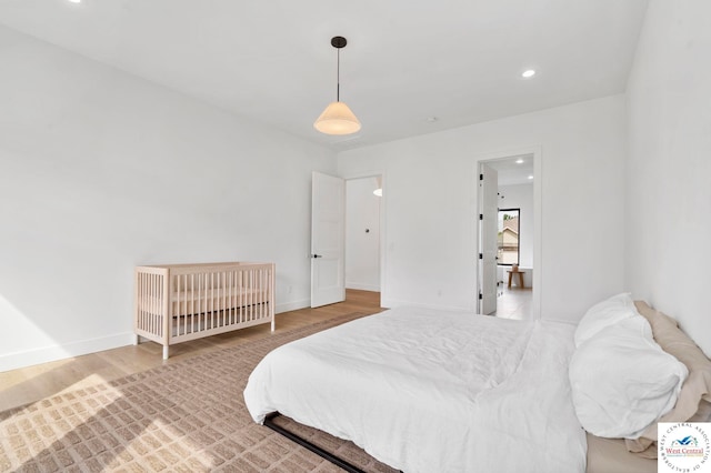 bedroom with wood finished floors, baseboards, and recessed lighting