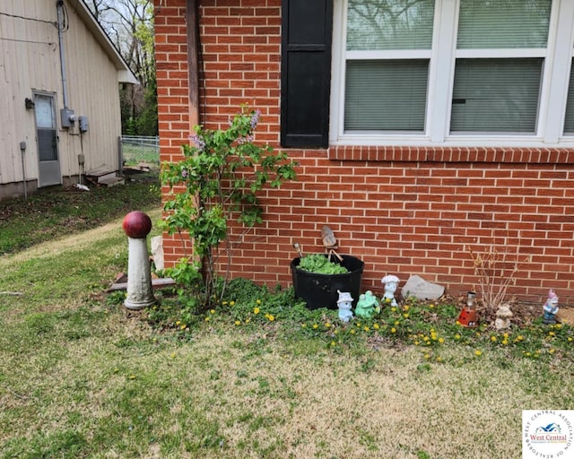 exterior view of brick siding, electric meter, and fence