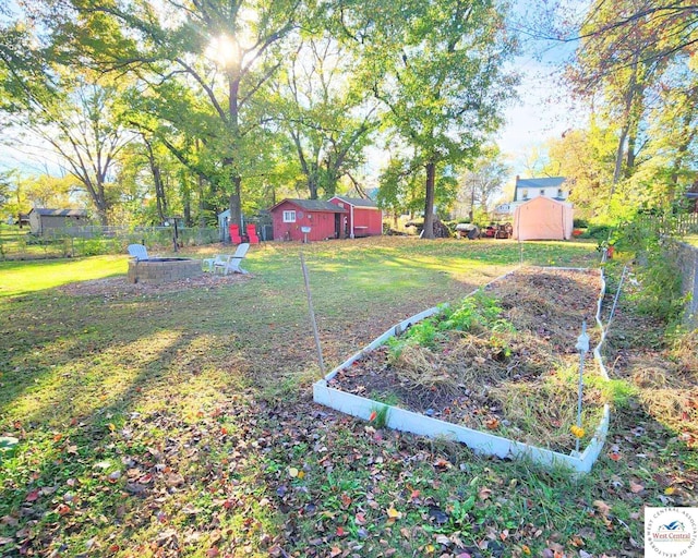 view of yard featuring a vegetable garden, an outbuilding, and a storage shed