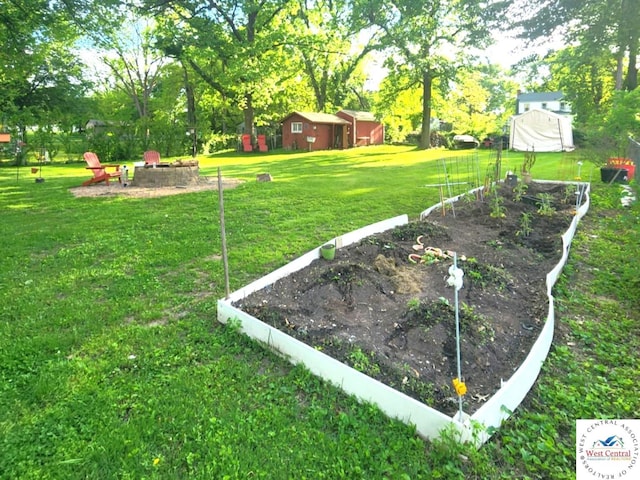 805 S Third St, Clinton, MO 64735 - view of green lawn with an outdoor fire pit, a vegetable garden, and view of scattered trees