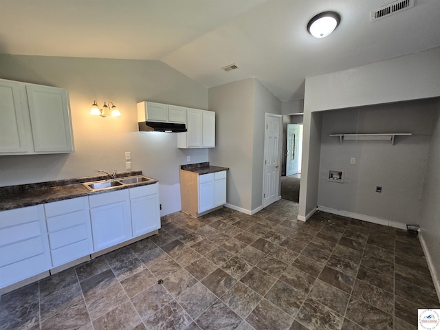 511 S Carter St, Clinton, MO 64735 - kitchen with lofted ceiling, white cabinetry, dark countertops, dark stone finish flooring, and under cabinet range hood