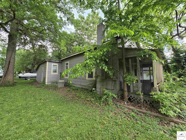 508 E Lincoln St, Clinton, MO 64735 - view of side of property with central air condition unit, a chimney, a yard, and a sunroom