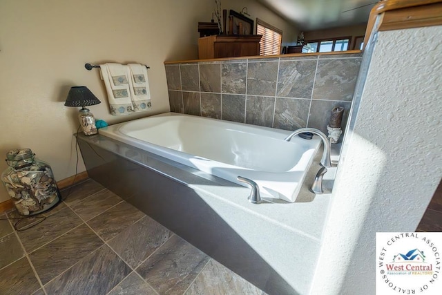 662 W 6th St, Schell City, MO 64783 - bathroom featuring a garden tub and baseboards