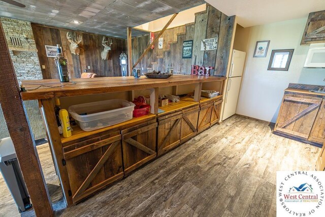 662 W 6th St, Schell City, MO 64783 - bar area featuring freestanding refrigerator, wood finished floors, and wood walls