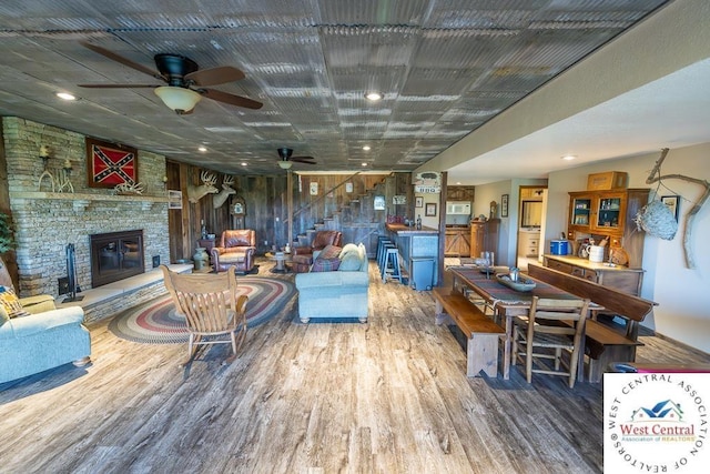 662 W 6th St, Schell City, MO 64783 - living area with wood finished floors, a stone fireplace, ceiling fan, stairway, and recessed lighting