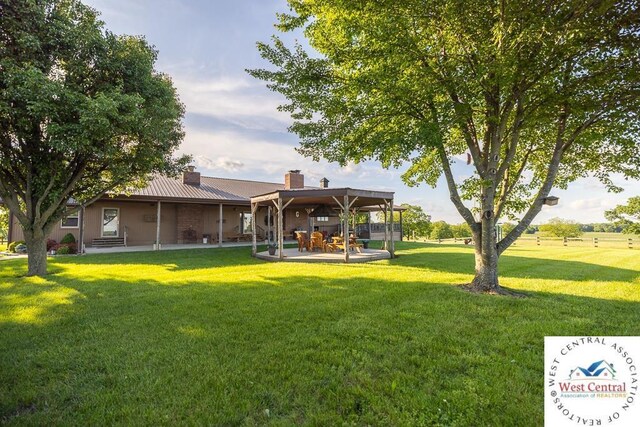 662 W 6th St, Schell City, MO 64783 - back of house with a chimney, a yard, and a patio area