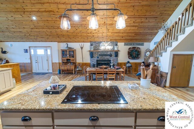 662 W 6th St, Schell City, MO 64783 - kitchen with black electric stovetop, wainscoting, wood ceiling, open floor plan, and light wood-type flooring