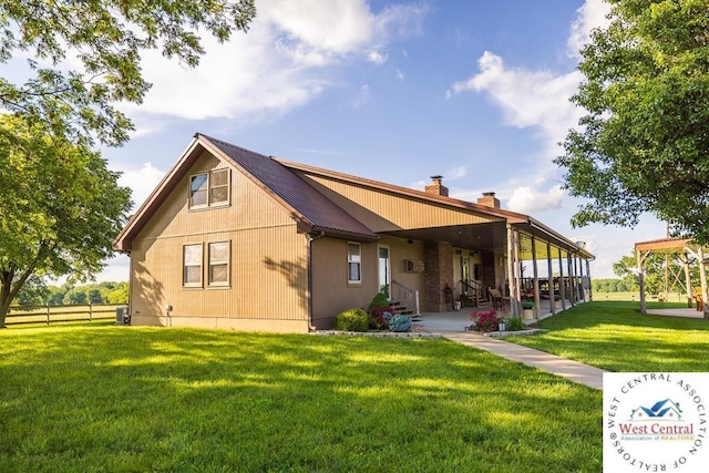 662 W 6th St, Schell City, MO 64783 - back of house featuring metal roof, a patio, and a chimney
